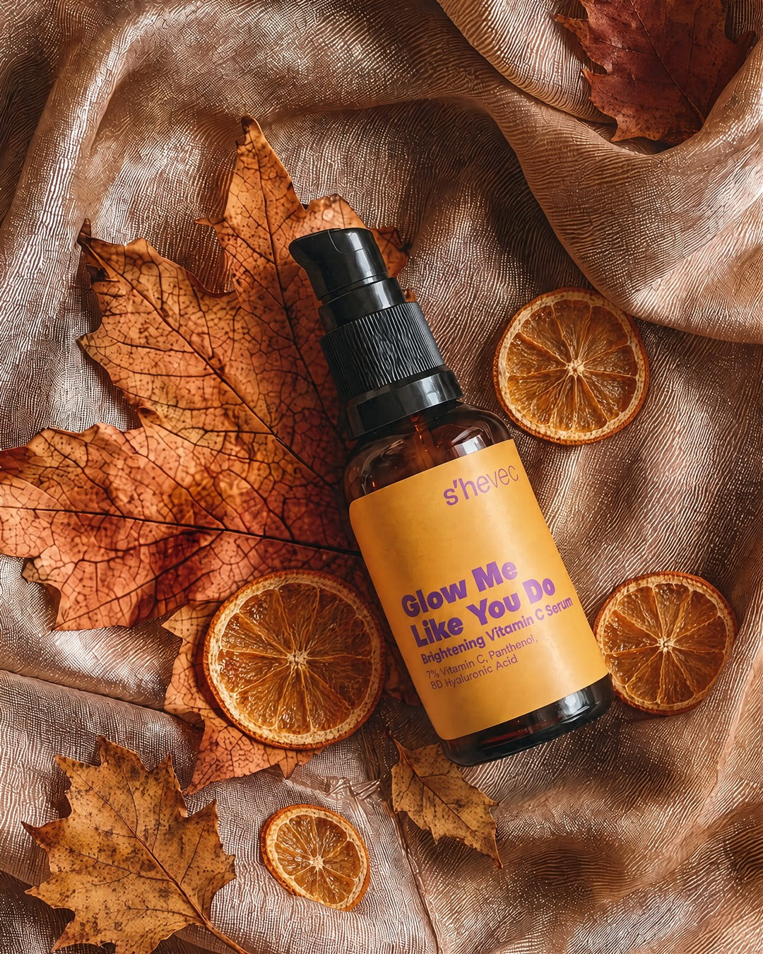 Glow Me Like You Do C vitamini serumu; kuru sonbahar yaprakları ve kurutulmuş portakal dilimleri arasında